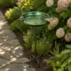 Antique green ground-stake bird bath beside hydrangeas and a garden path