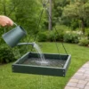 Water draining through the mesh tray of a hanging platform bird feeder during cleaning
